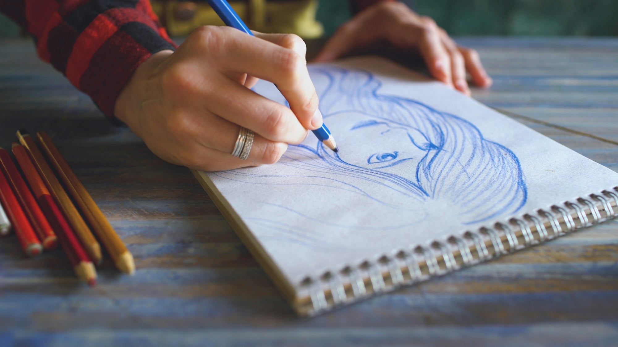 Artist hand drawing a pencil portrait sketch